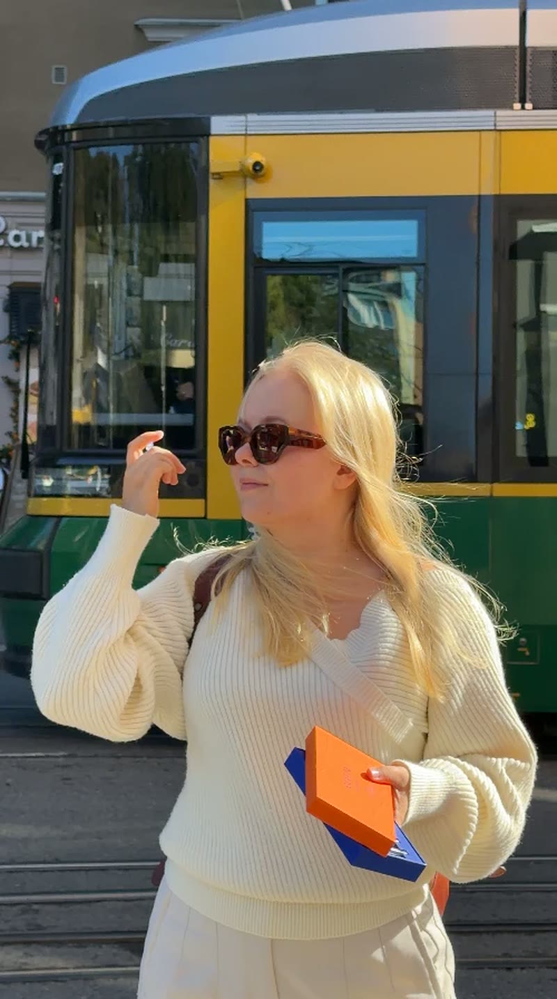 Aino by a Helsinki tram with an Angeline Perfume box